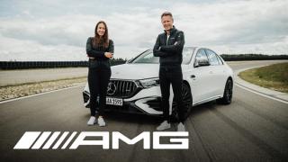 Zwei Personen stehen mit verschränkten Armen vor einem weißen Mercedes-AMG E 53 Sedan Hybrid auf einer Teststrecke