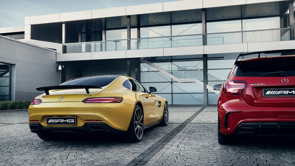 Familienbande symbolisiert durch zwei verschiedene AMG Fahrzeuge vor einem Gebäude