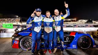 Three racing drivers stand in front of their Mercedes-AMG GT