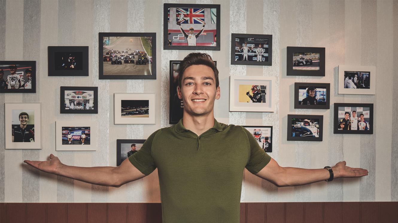 George Russel in front of a picture wall