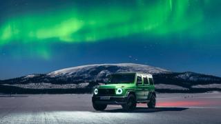 Eine Mercedes-AMG G-Klasse mit Polarlichtern im Hintergrund.