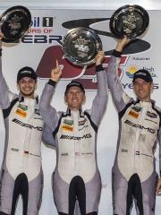 Three Mercedes-AMG racing drivers raise their shells into the air