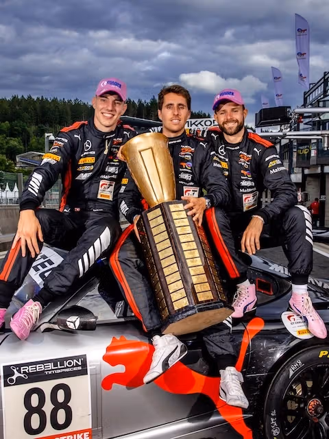 AMG GT racing drivers sit on their GT and present the trophy.