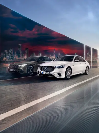 Zwei Mercedes-AMG S 63 E PERFORMANCE Limousinen fahren nebeneinander her.