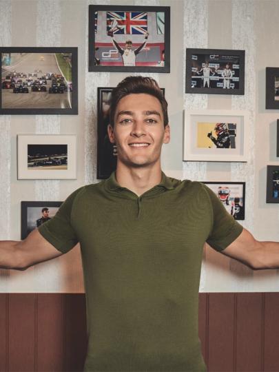 George Russel vor einer Fotowand