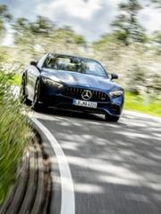 Ein dunkler Mercedes-AMG fährt auf einer Landstraße durch eine Kurve auf den Betrachter zu